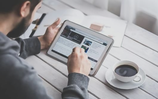 Man on iPad with coffee
