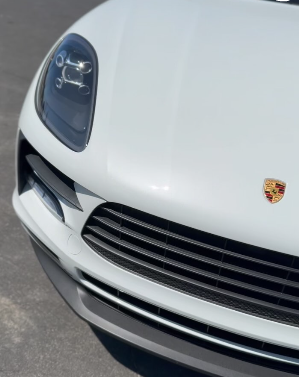 A white porsche is parked on the street
