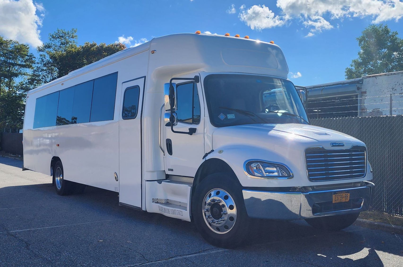 A large white bus is parked on the side of the road.