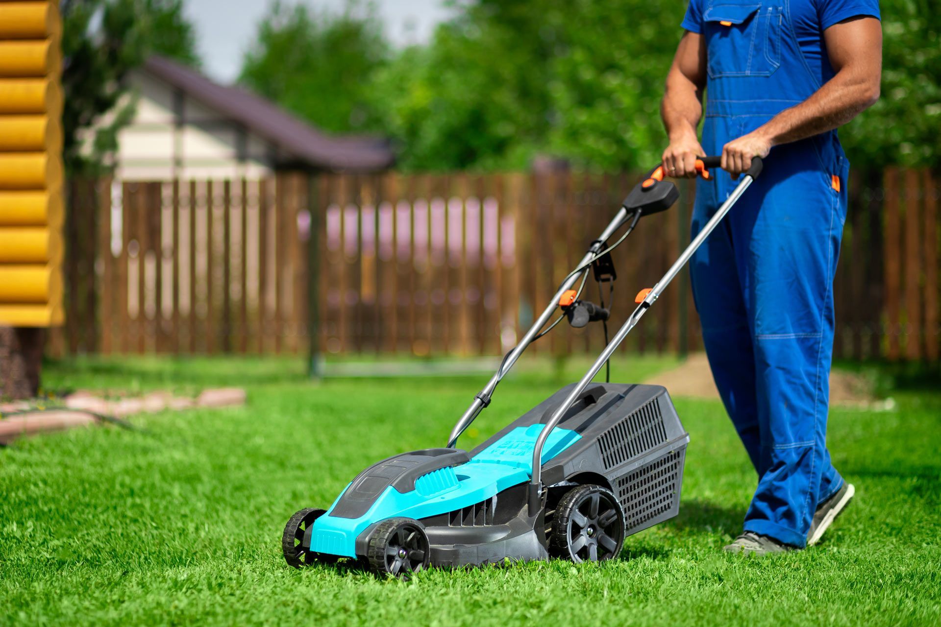 Gardener mowing and pruning lawn, showcasing professional landscaping services. Gardener mowing and pruning lawn, showcasing professional landscaping services.