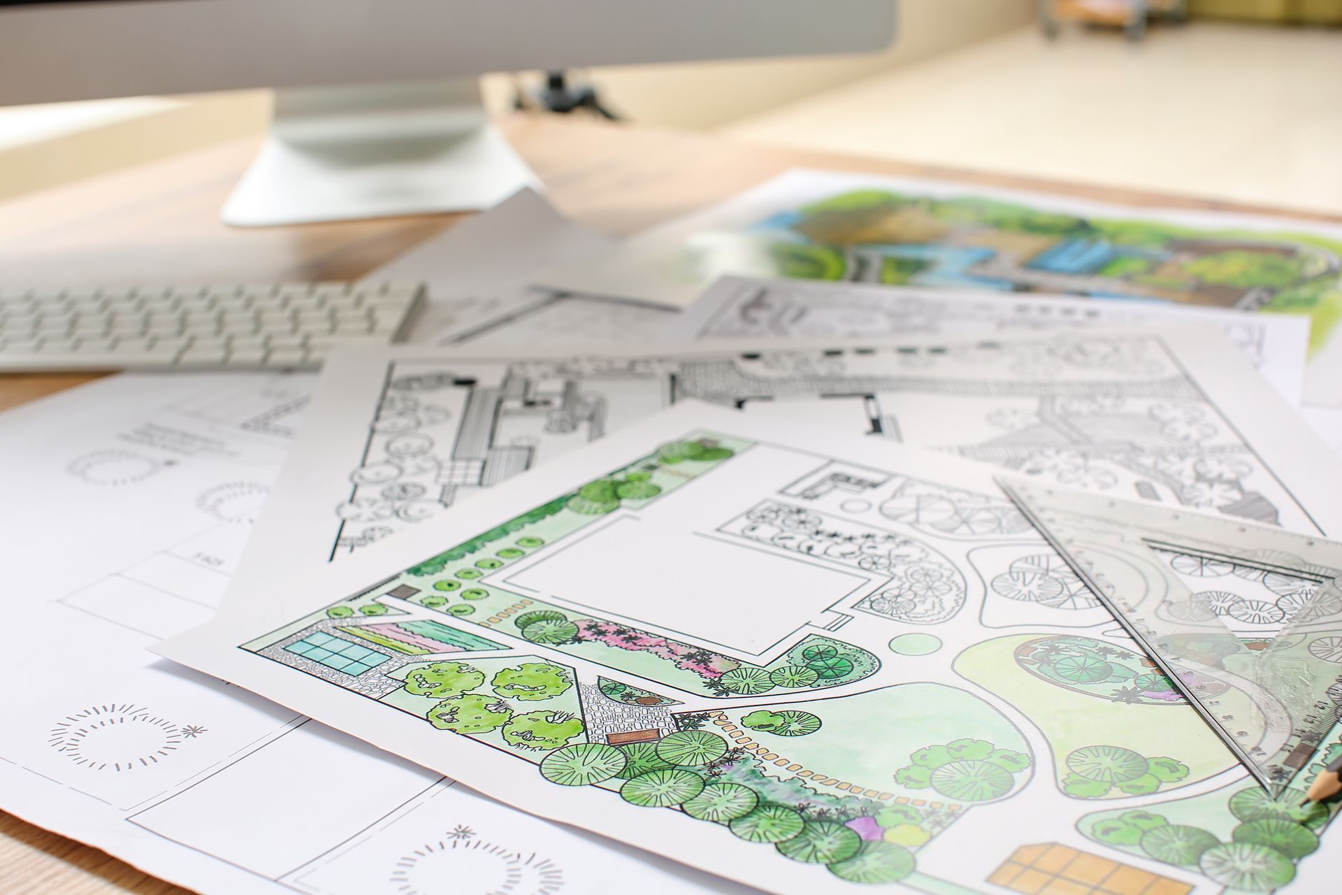 A landscape design project laid out on a wooden table.