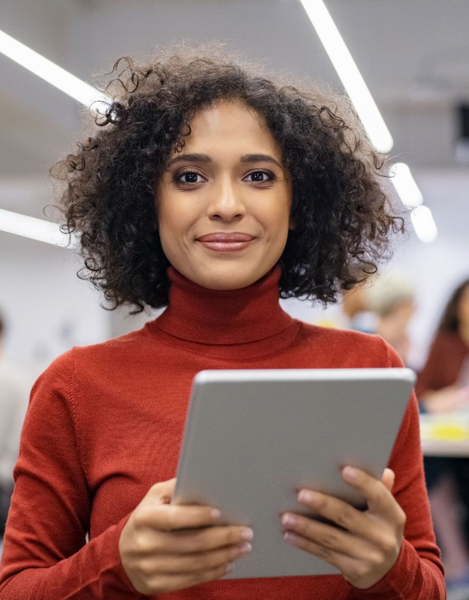 A woman in a red sweater is holding a tablet computer.