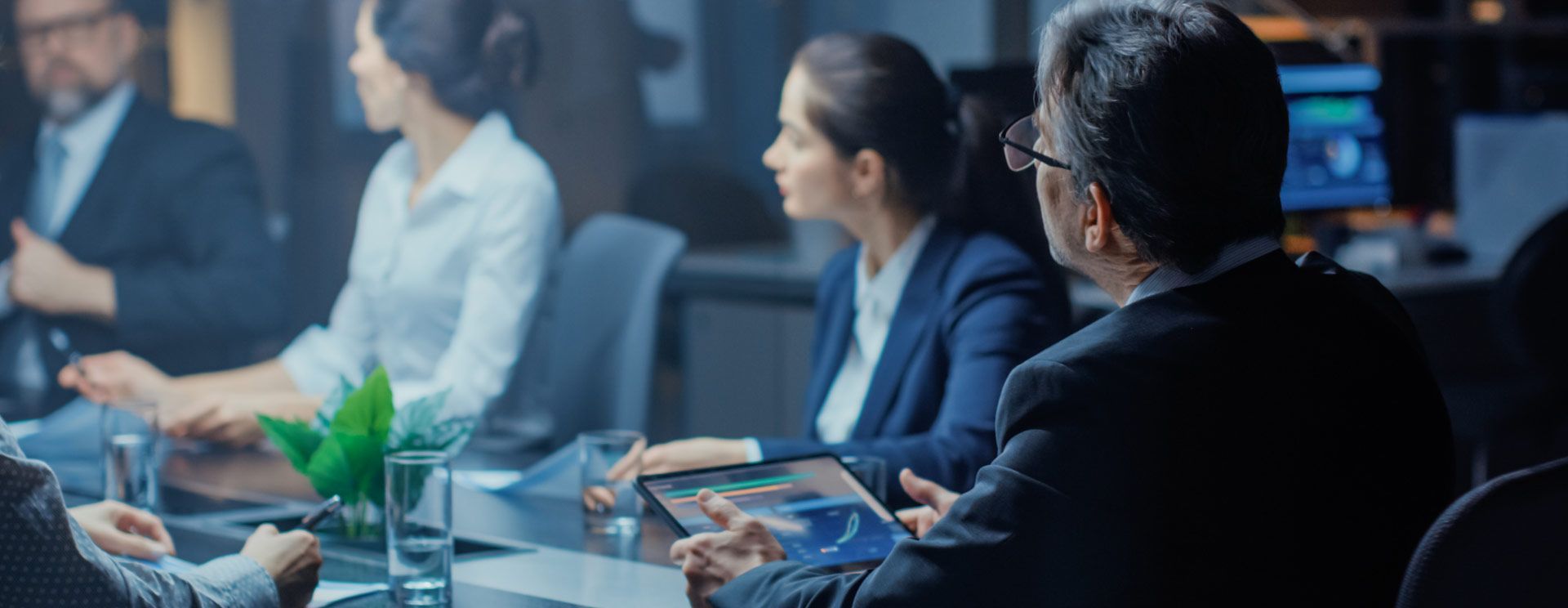 A group of business people are sitting around a table having a meeting.