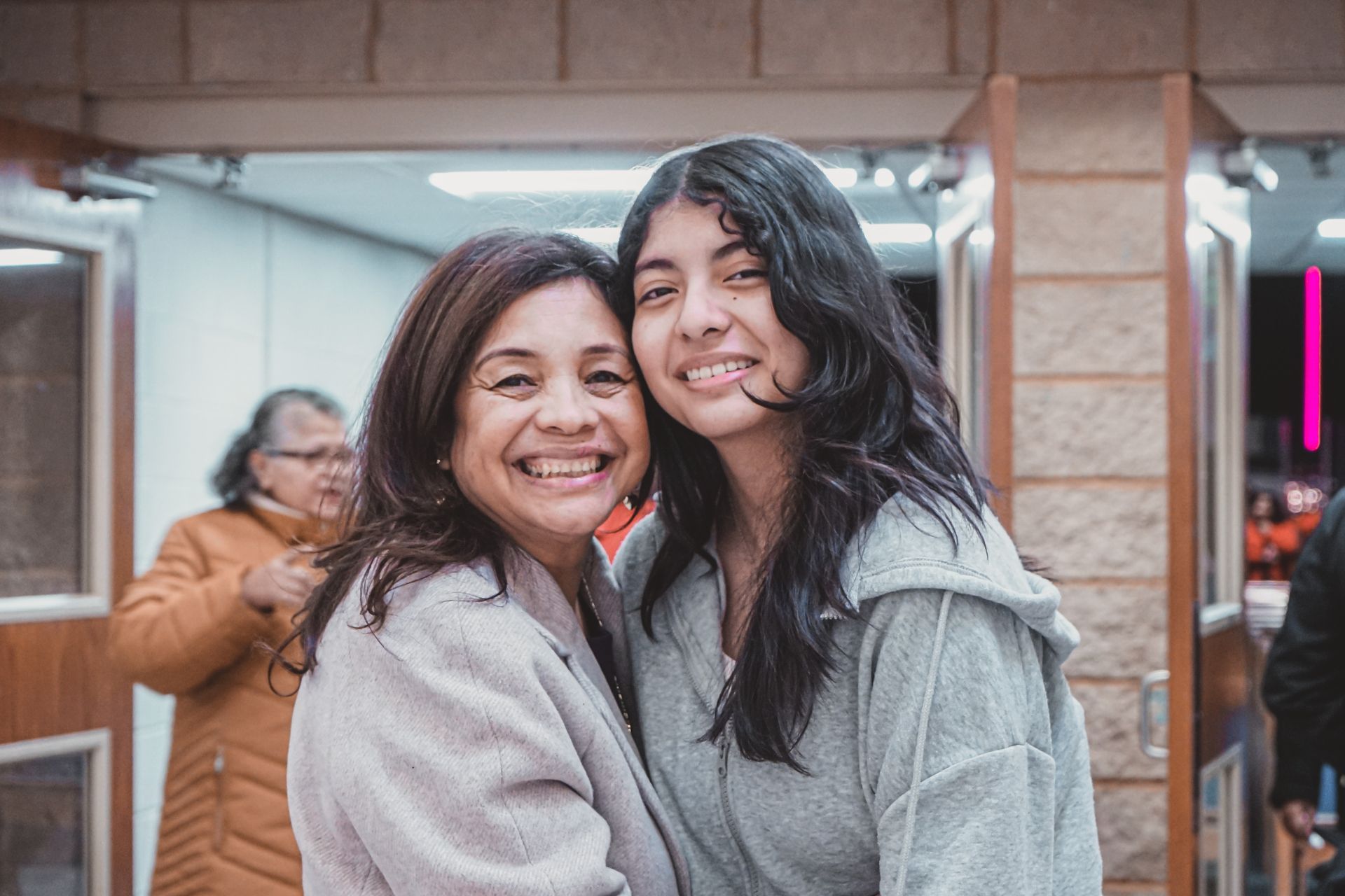 Dos mujeres se abrazan y sonríen para la cámara.