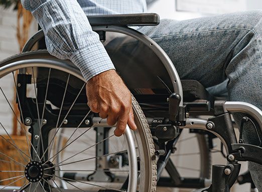 Person adjusting the wheel of a wheelchair indoors