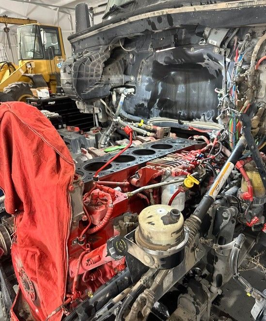 A man is working on a truck engine with a wrench.