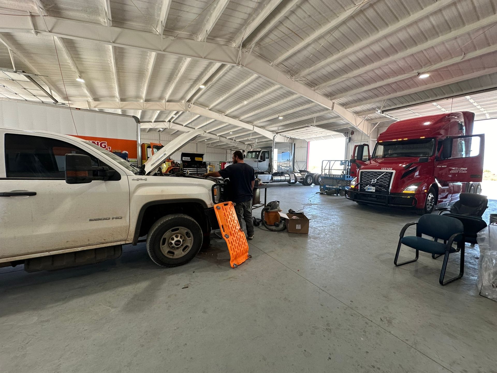 A man is working on a truck in a garage.