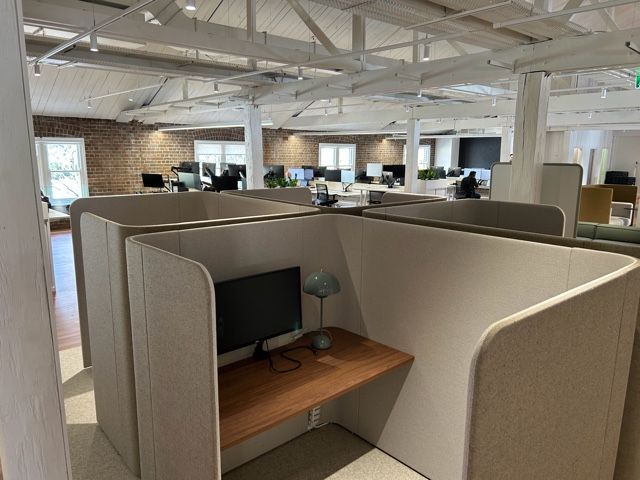 A cubicle with a desk and a computer in an office