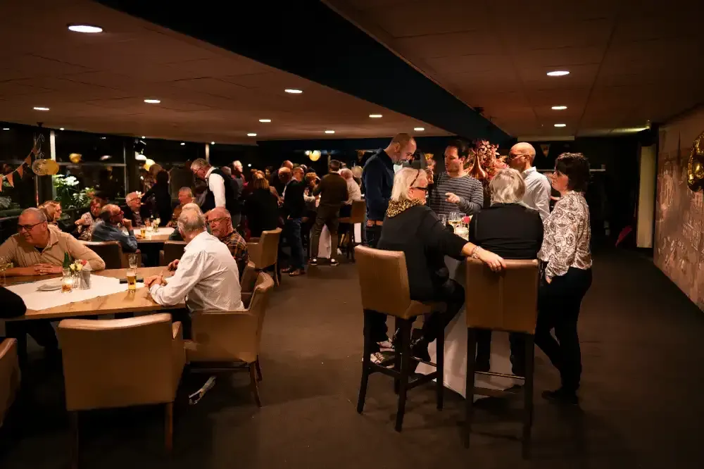 een groep mensen zit aan tafels in een restaurant.