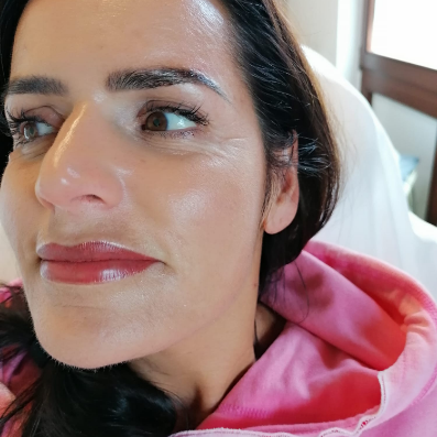 Eine Nahaufnahme des Gesichts einer Frau, die einen rosa Kapuzenpullover trägt