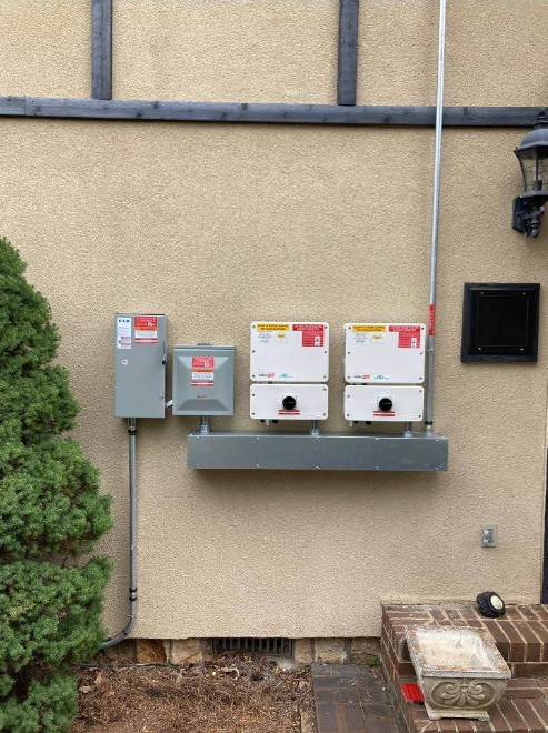 Two solar panels are mounted on the side of a building.