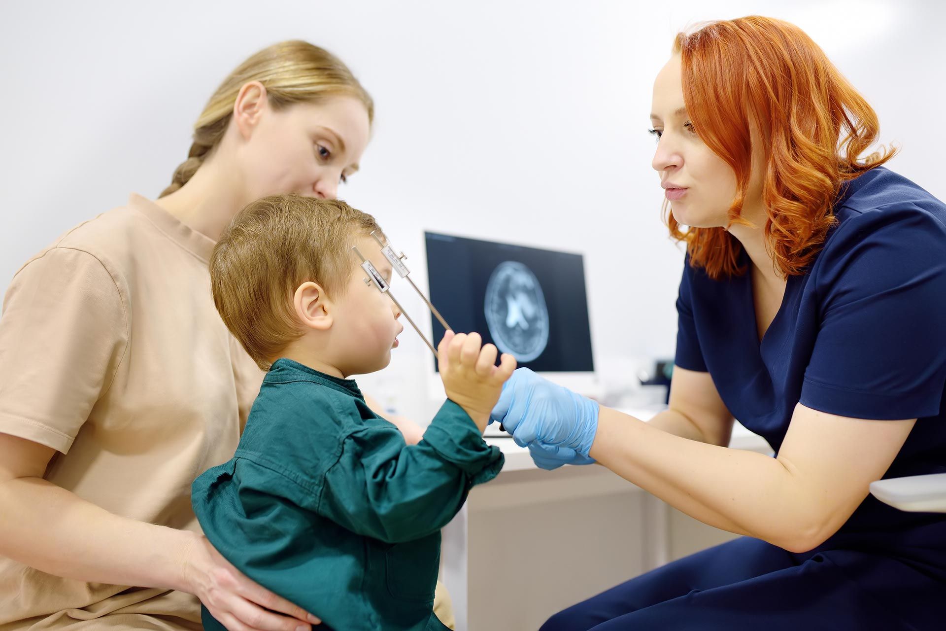 Doctor showing an X-ray to a child while a parent watches in a clinic