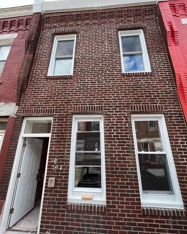 A red brick building with white windows and a white door.