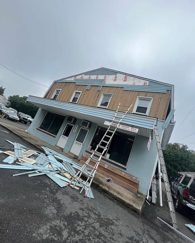 A building with a ladder on the side of it is being remodeled.