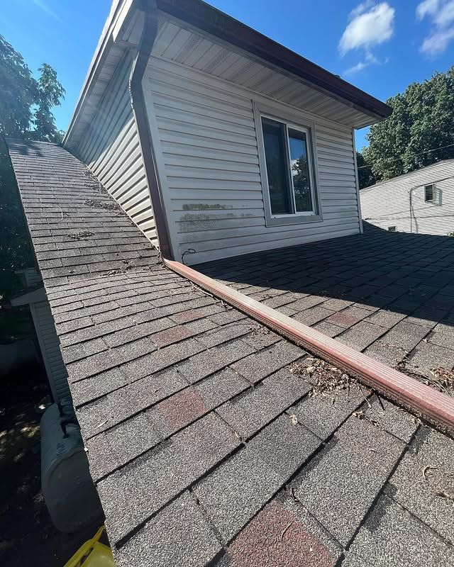 A house with a roof that is missing shingles and a window.