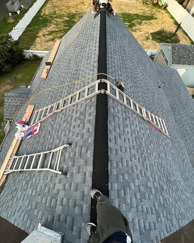 A person is standing on the roof of a house.