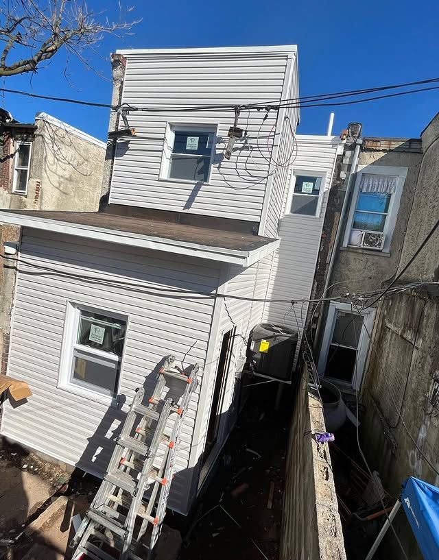 A ladder is sitting on the side of a house.