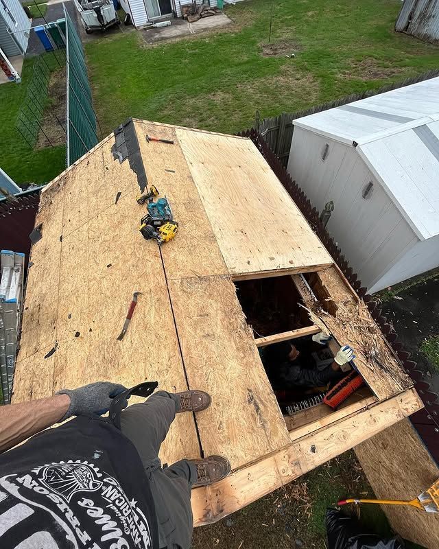 A man is working on the roof of a house.