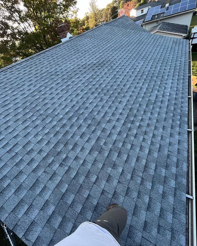 A person is standing on the roof of a house.