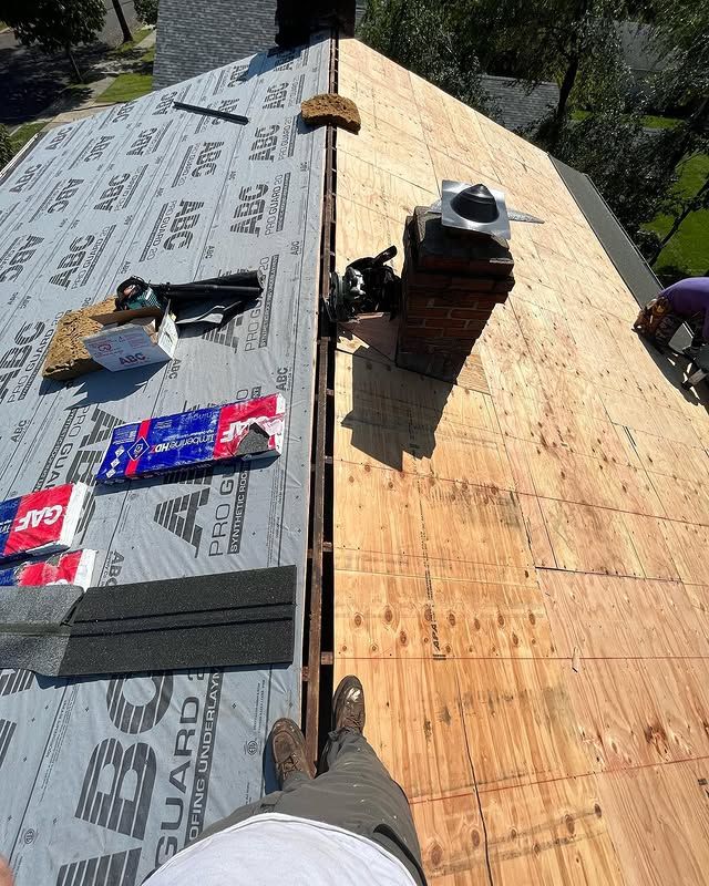 A person is standing on the roof of a house.
