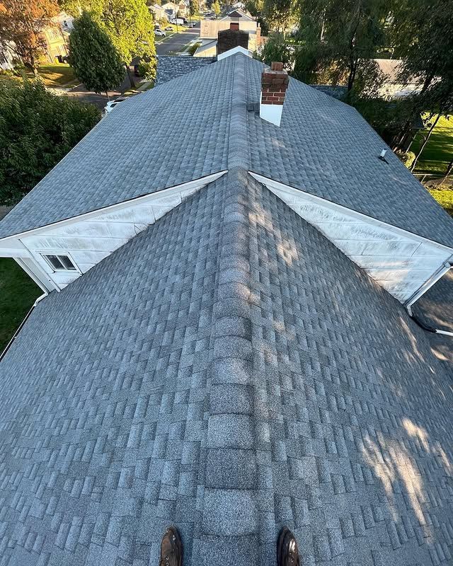A person is standing on the roof of a house.