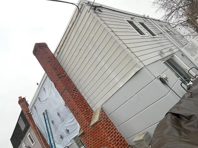 A white house with a brick chimney on the side