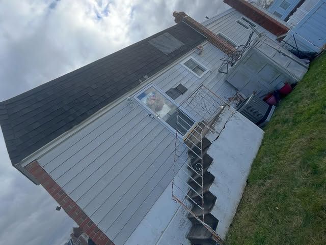 The back of a house with stairs leading up to it.