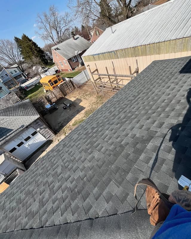 A person is standing on the roof of a house.