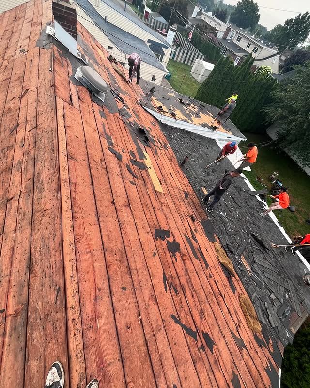 A group of people are working on a wooden roof.