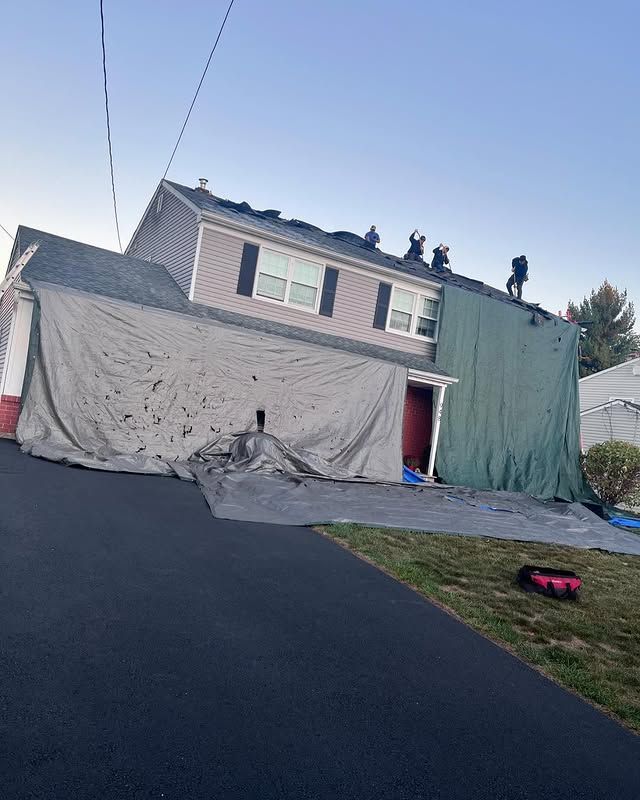 A house is being remodeled with a tarp on the side of it.