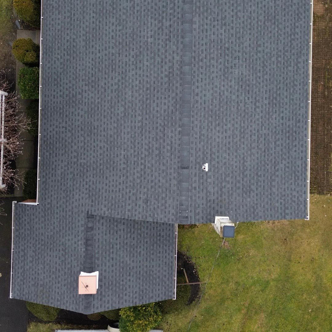 An aerial view of a house with a roof and a chimney.