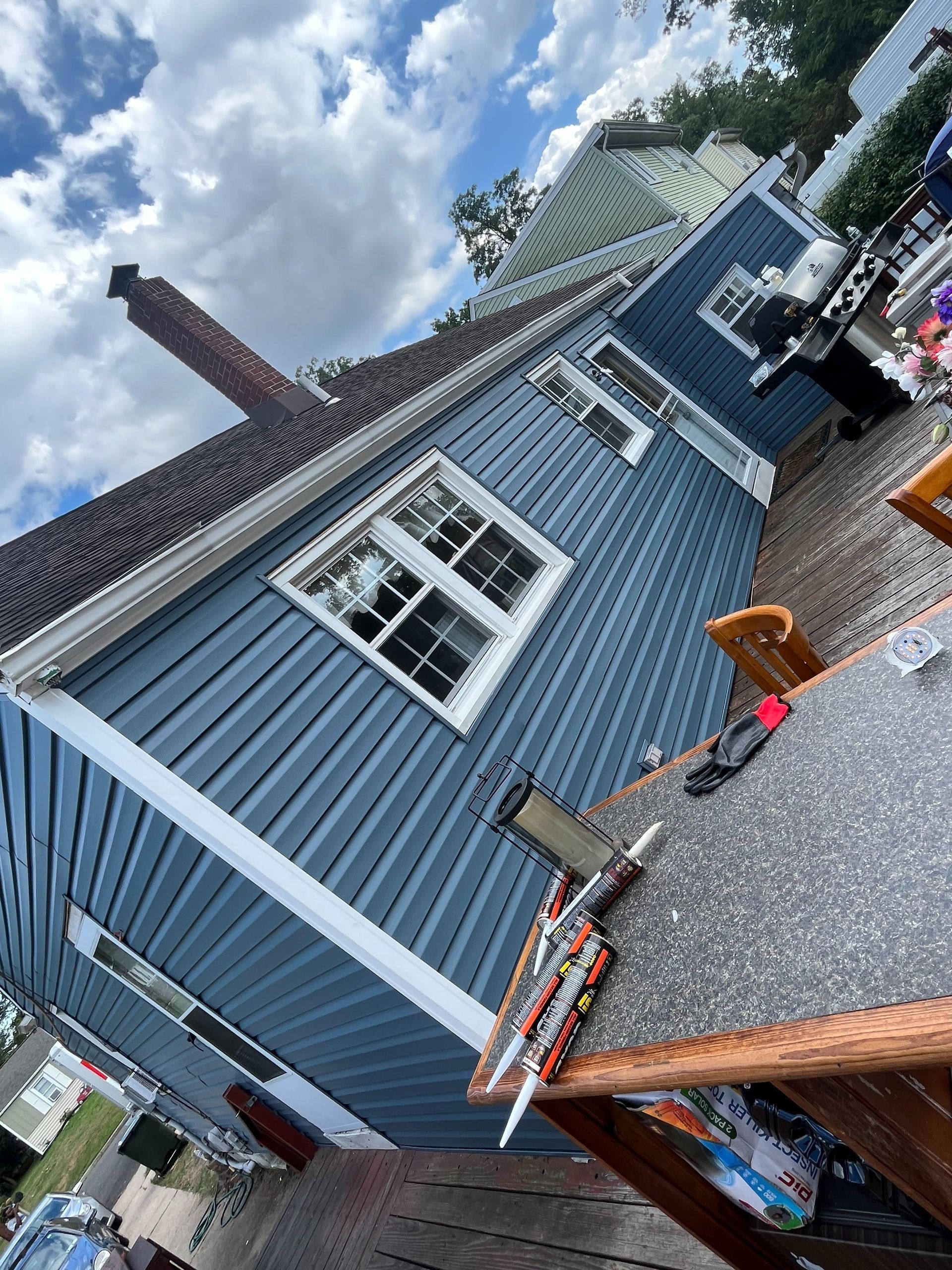 A blue house with a table and chairs in front of it.
