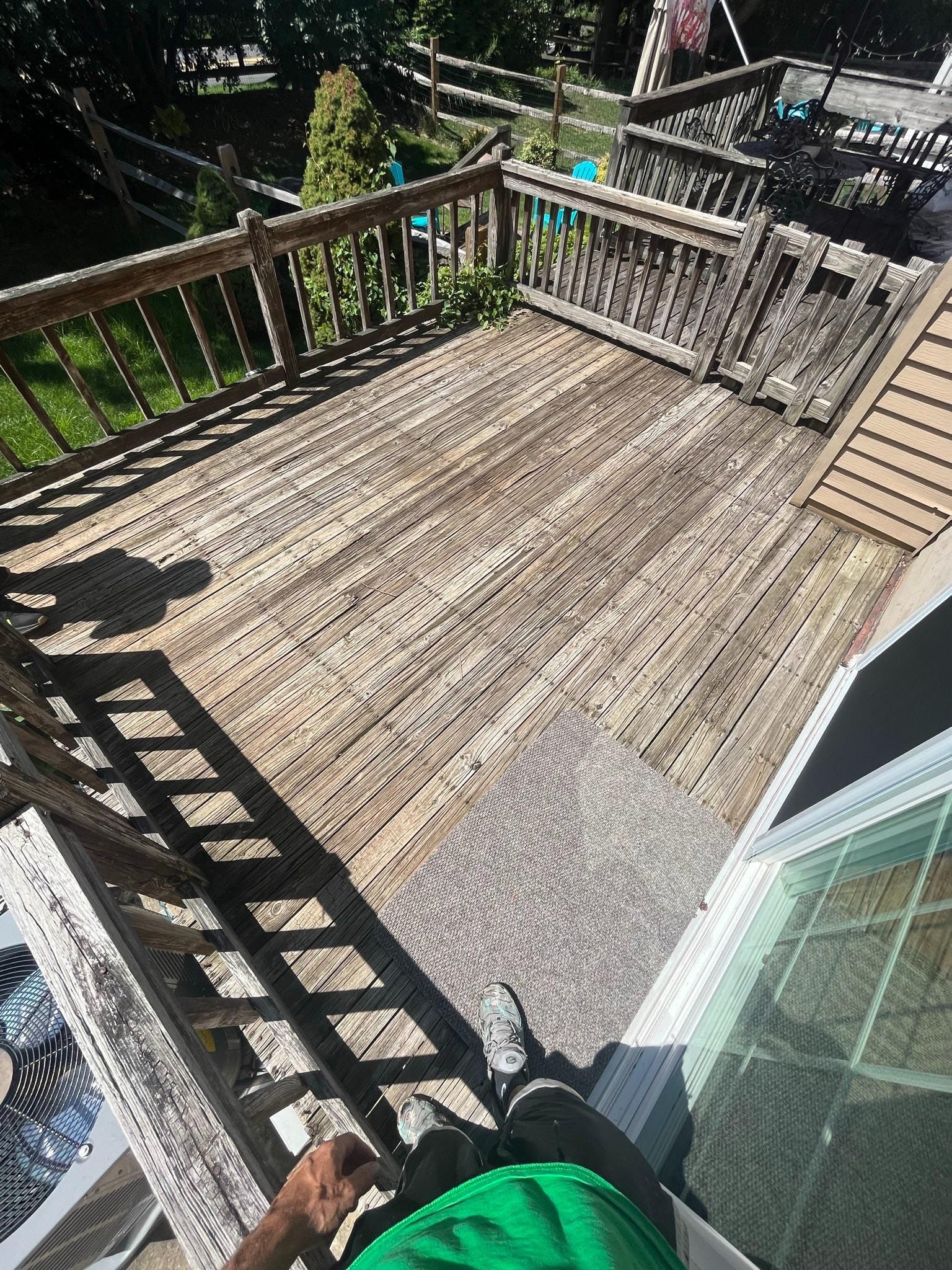 A person is sitting on top of a wooden deck.