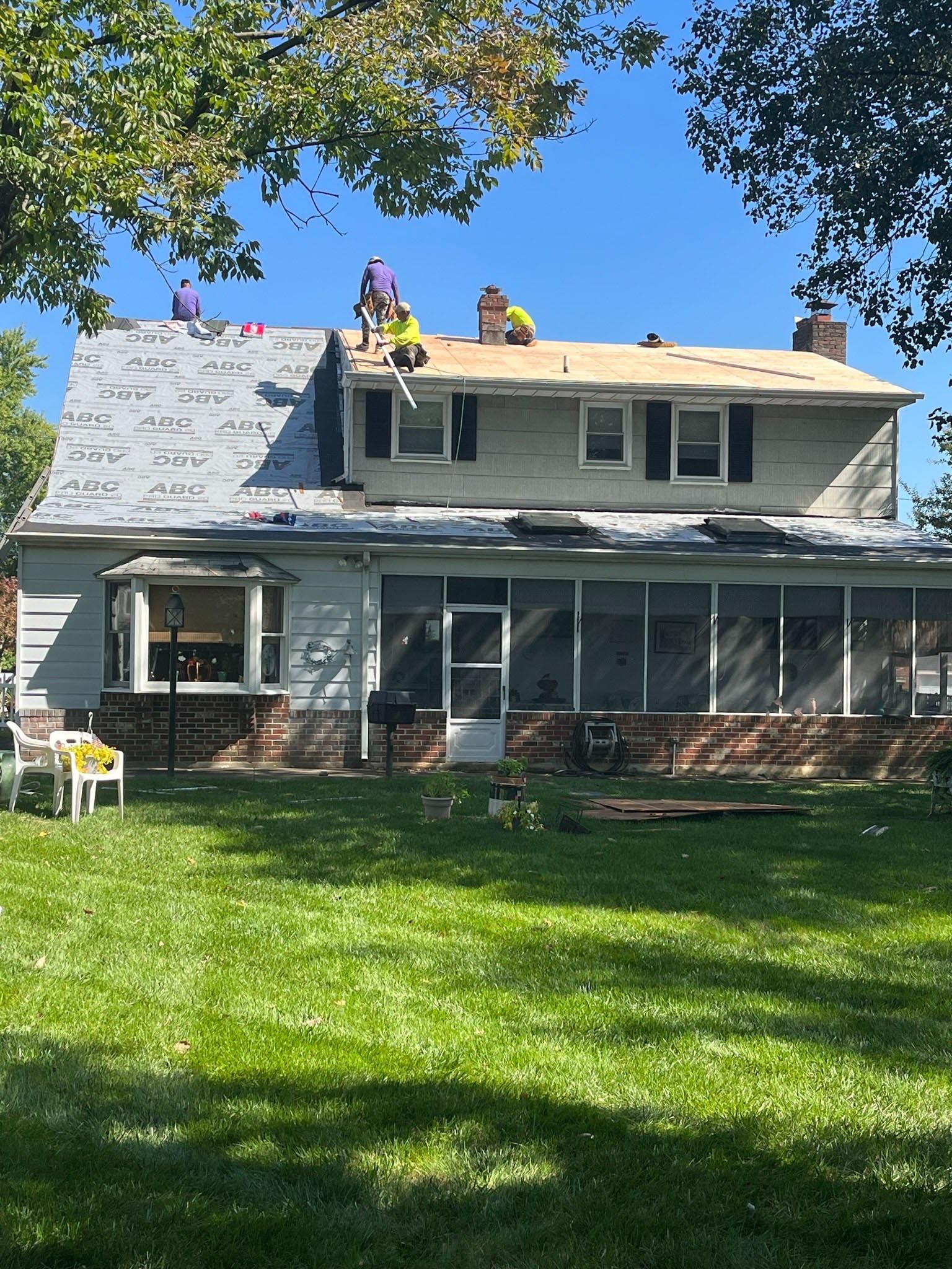 Two men are working on the roof of a house.