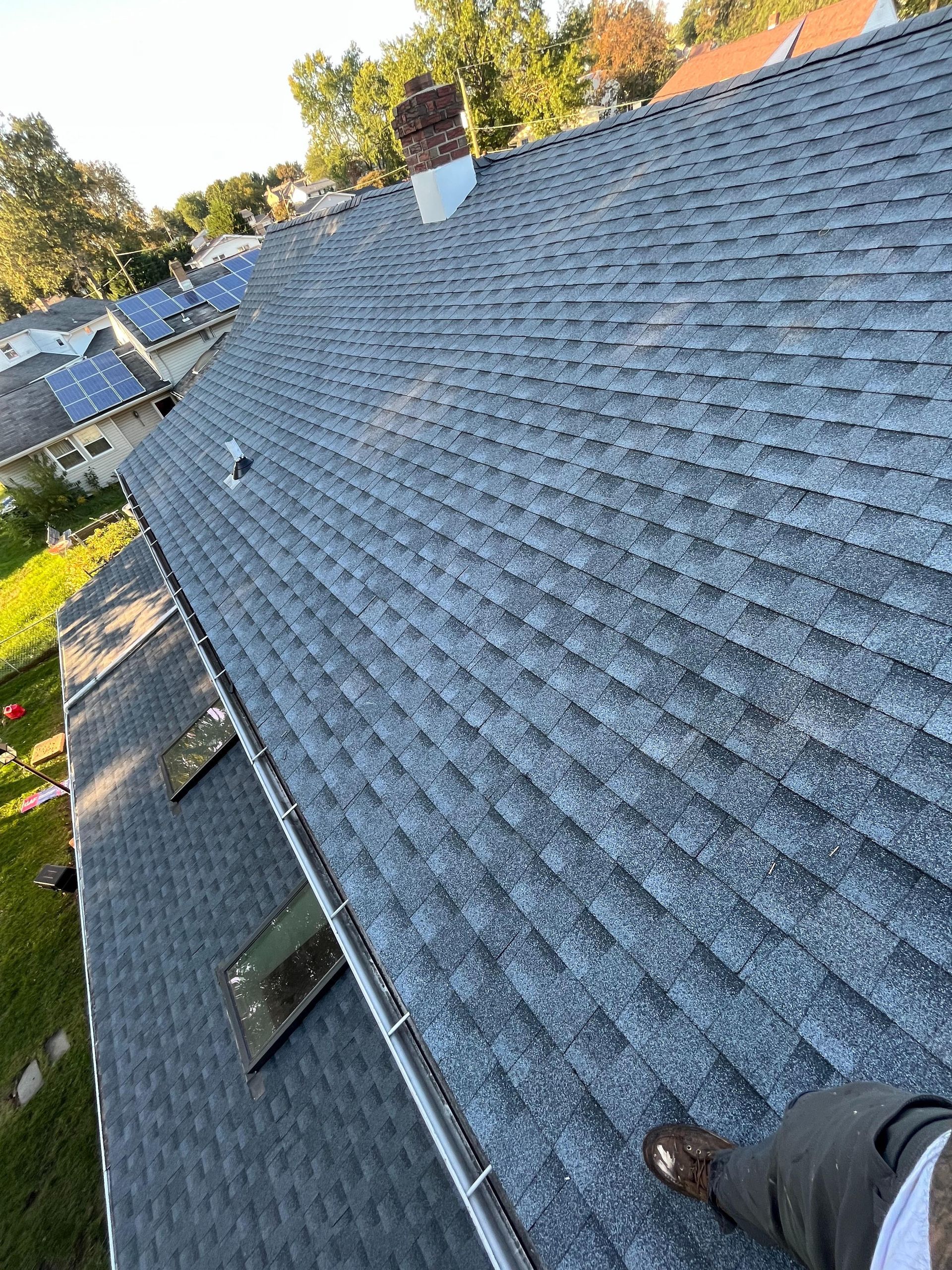 A person is standing on the roof of a house.