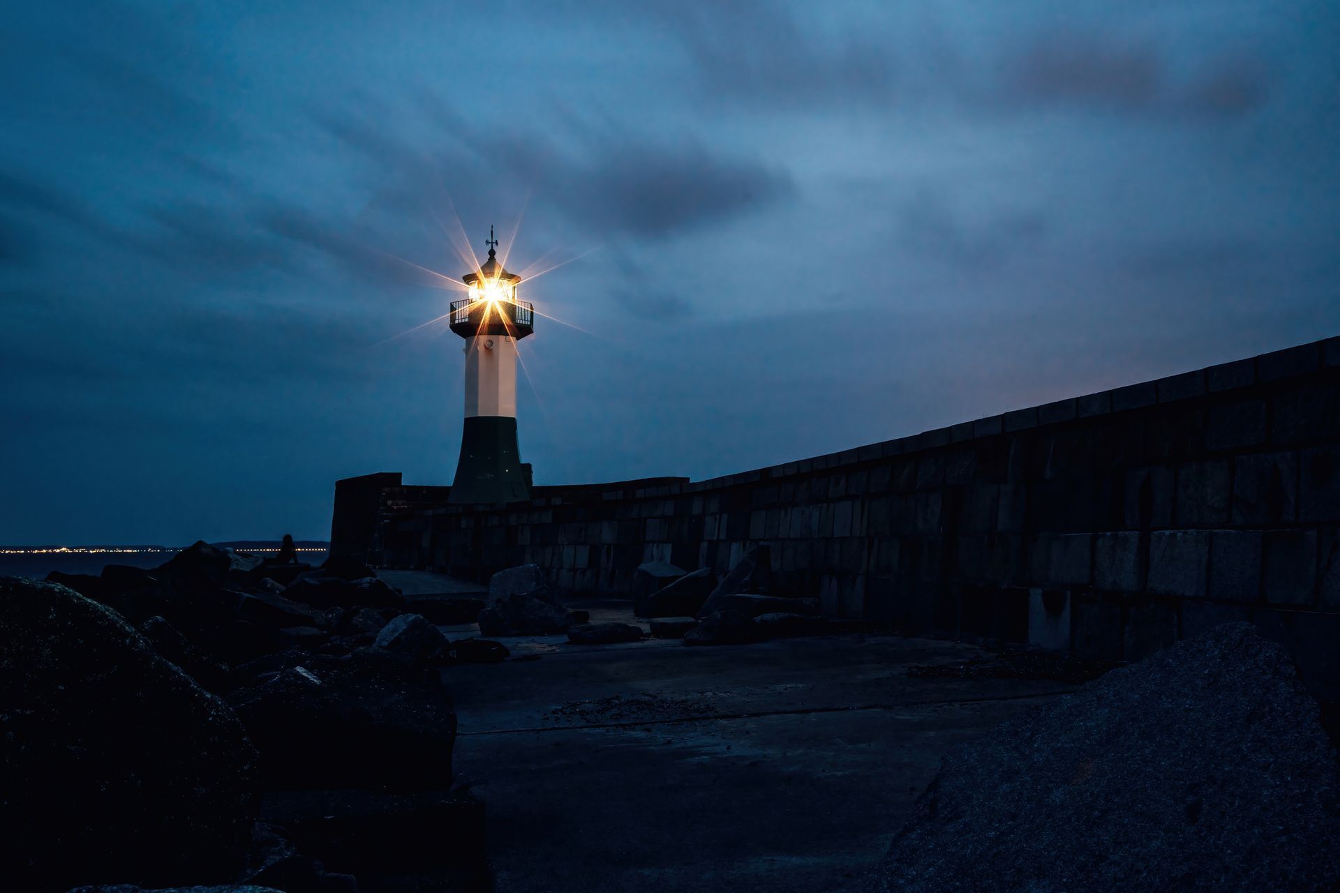 A lighthouse is lit up at night in the dark.