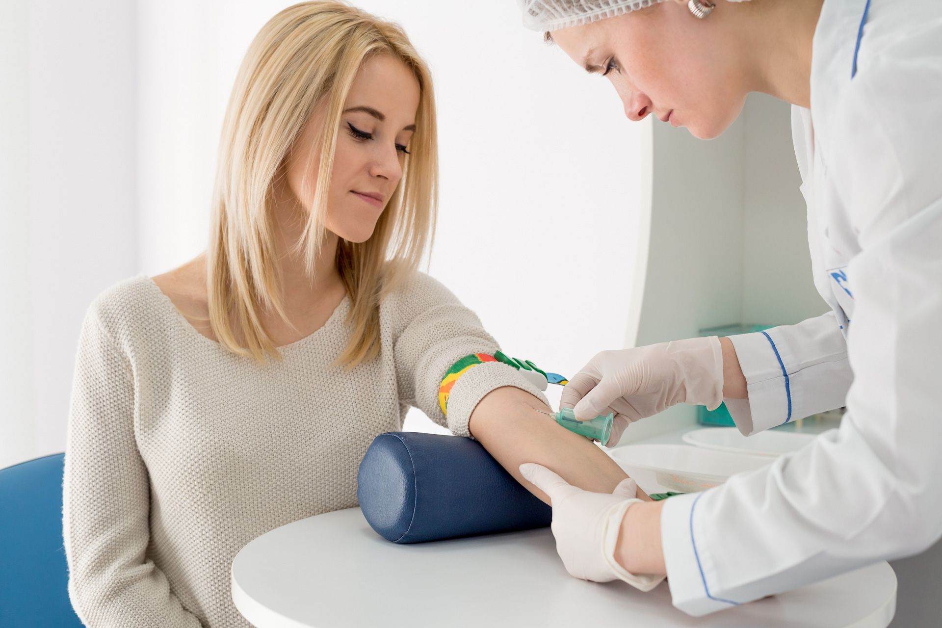 Nurse doing a blood drawing to a woman patient
