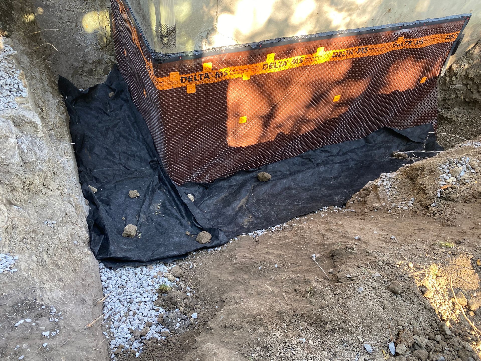 A drainage system is being installed on the side of a building.