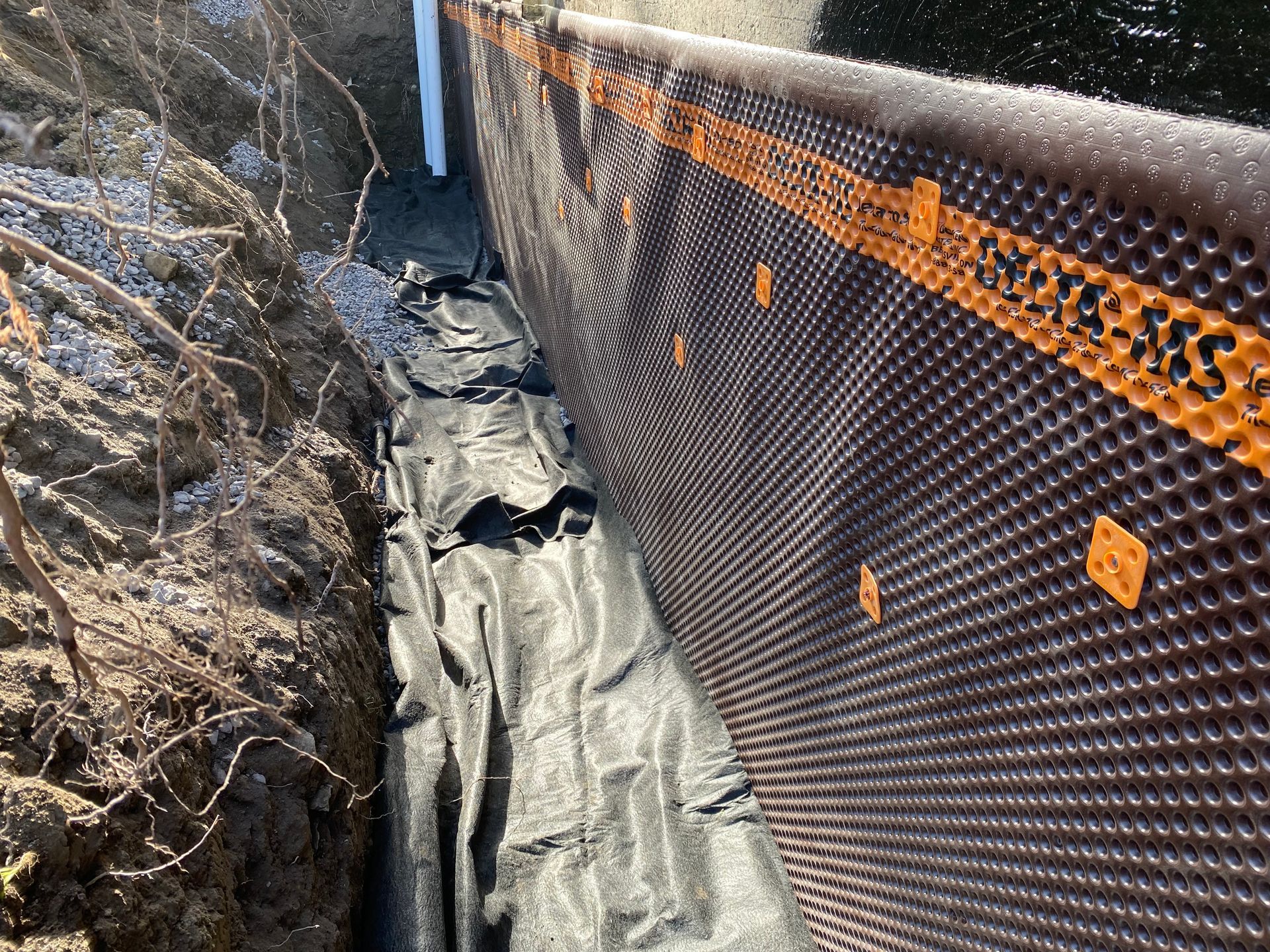 A drainage system is being installed on the side of a building.
