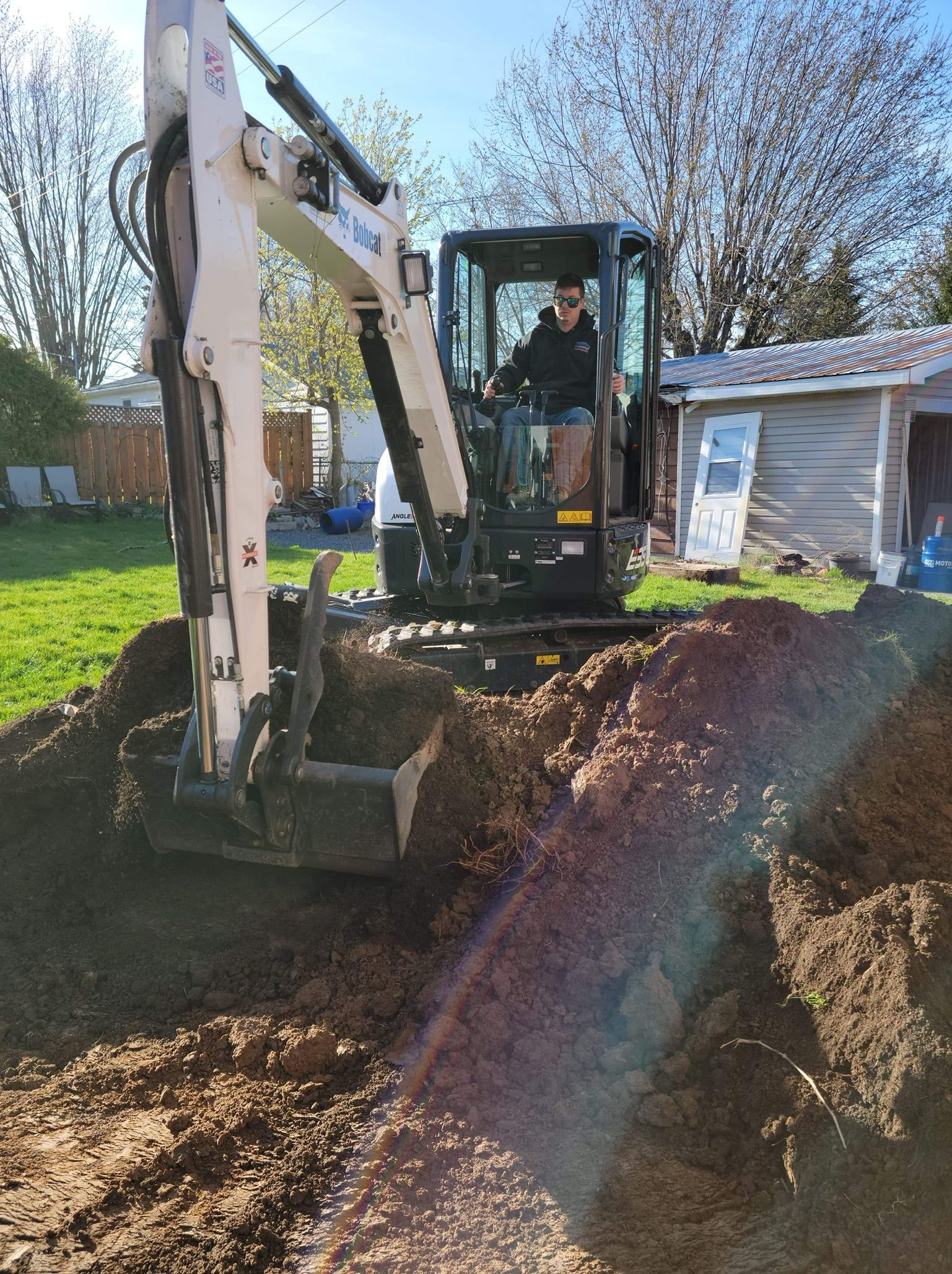 A man is driving an excavator through a hole in the ground.