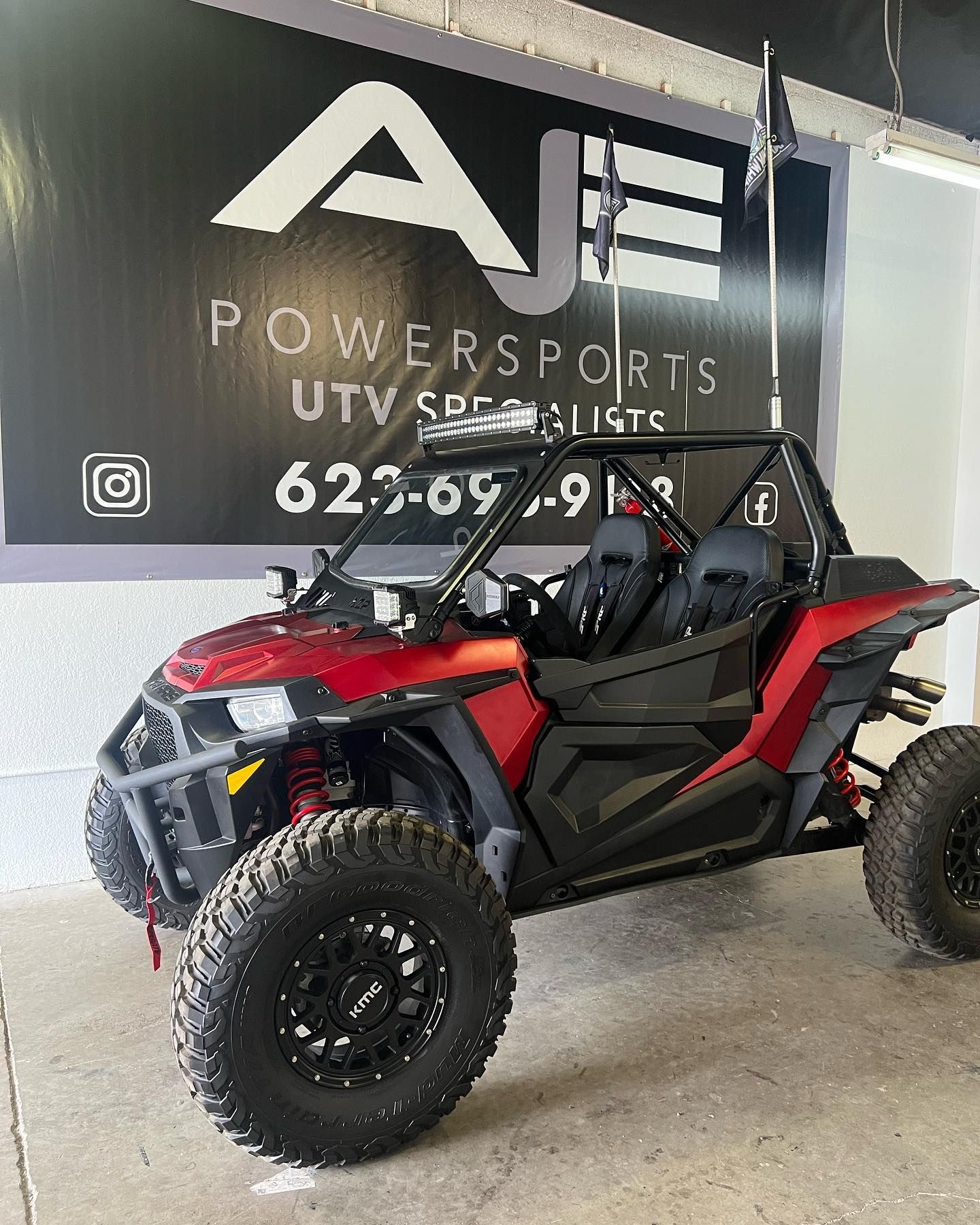 A red atv is parked in front of a powersports utv specialists sign.