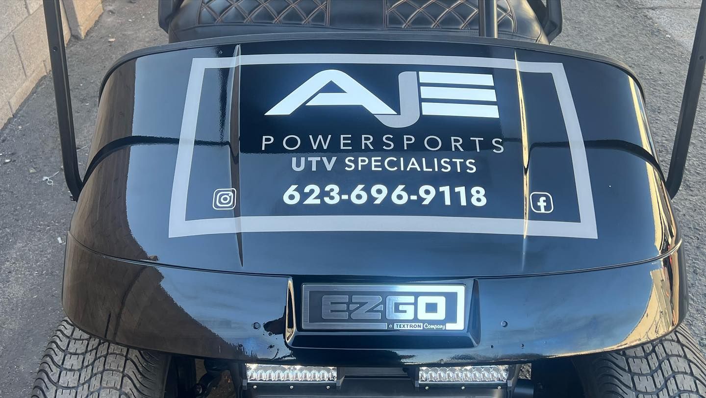 A black golf cart with aje powersports written on the back
