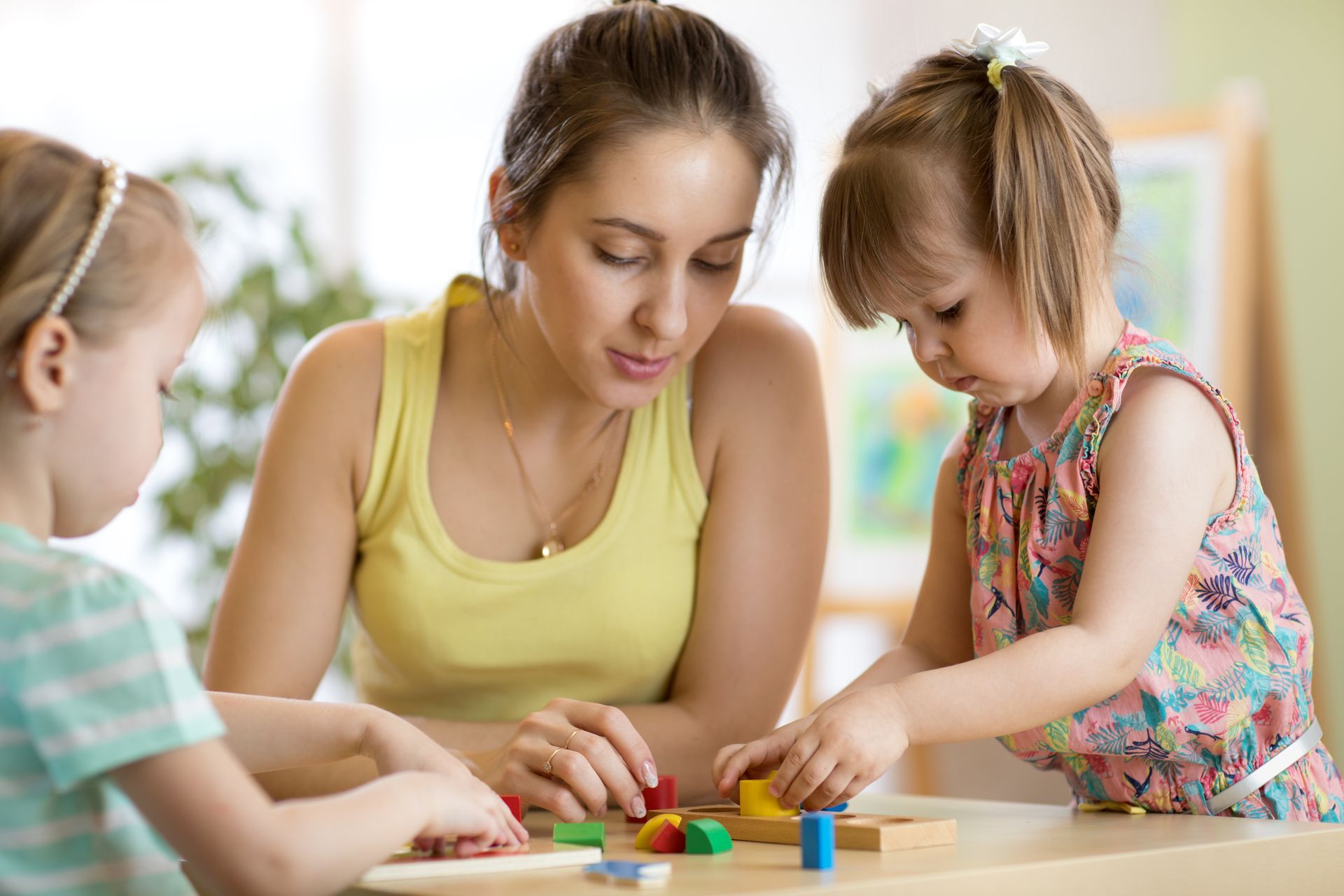 Children with teacher playing educational toys.