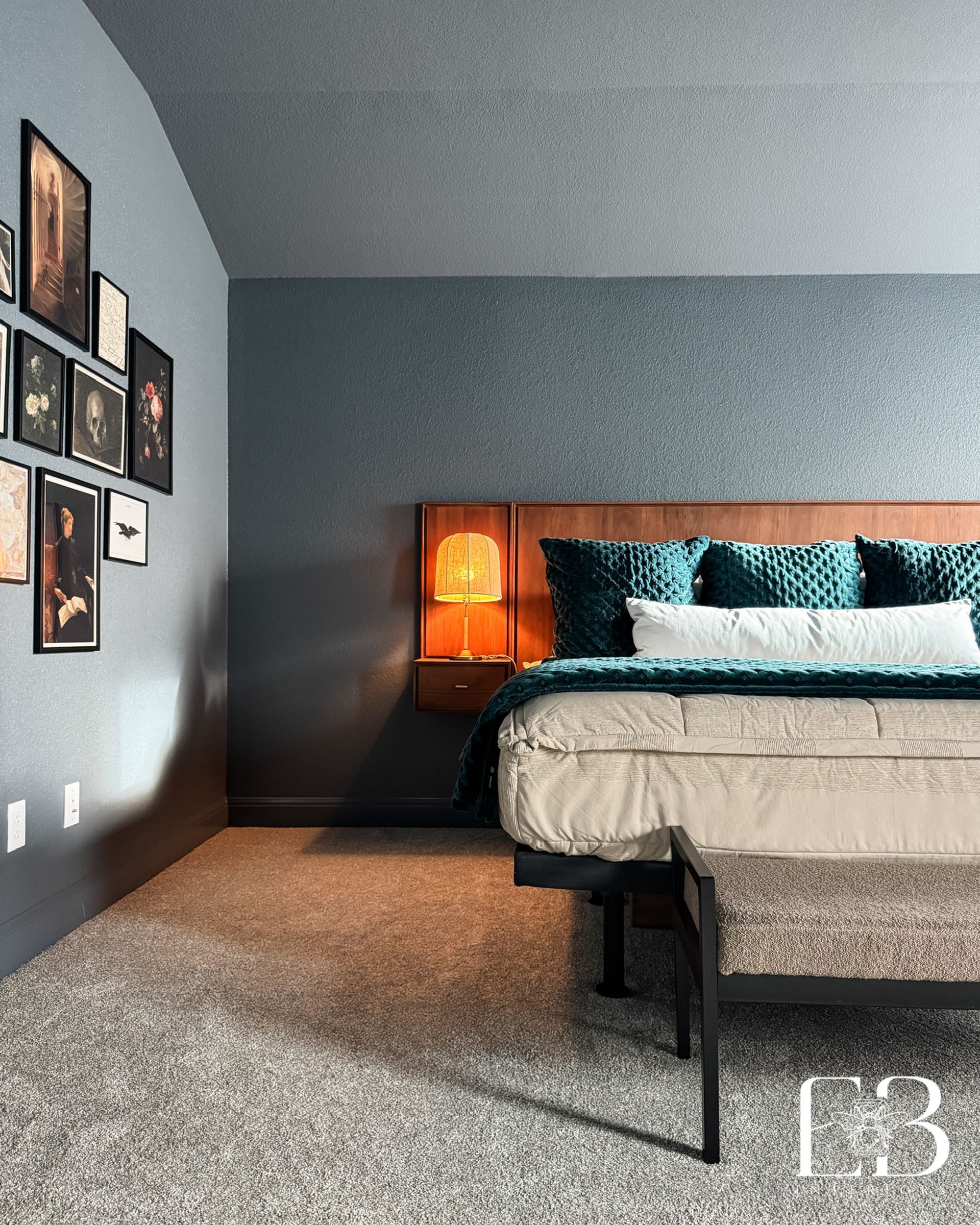Dark blue bedroom by Emerald Bee Interiors with walnut headboard, teal velvet bedding, and an artful gallery wall.