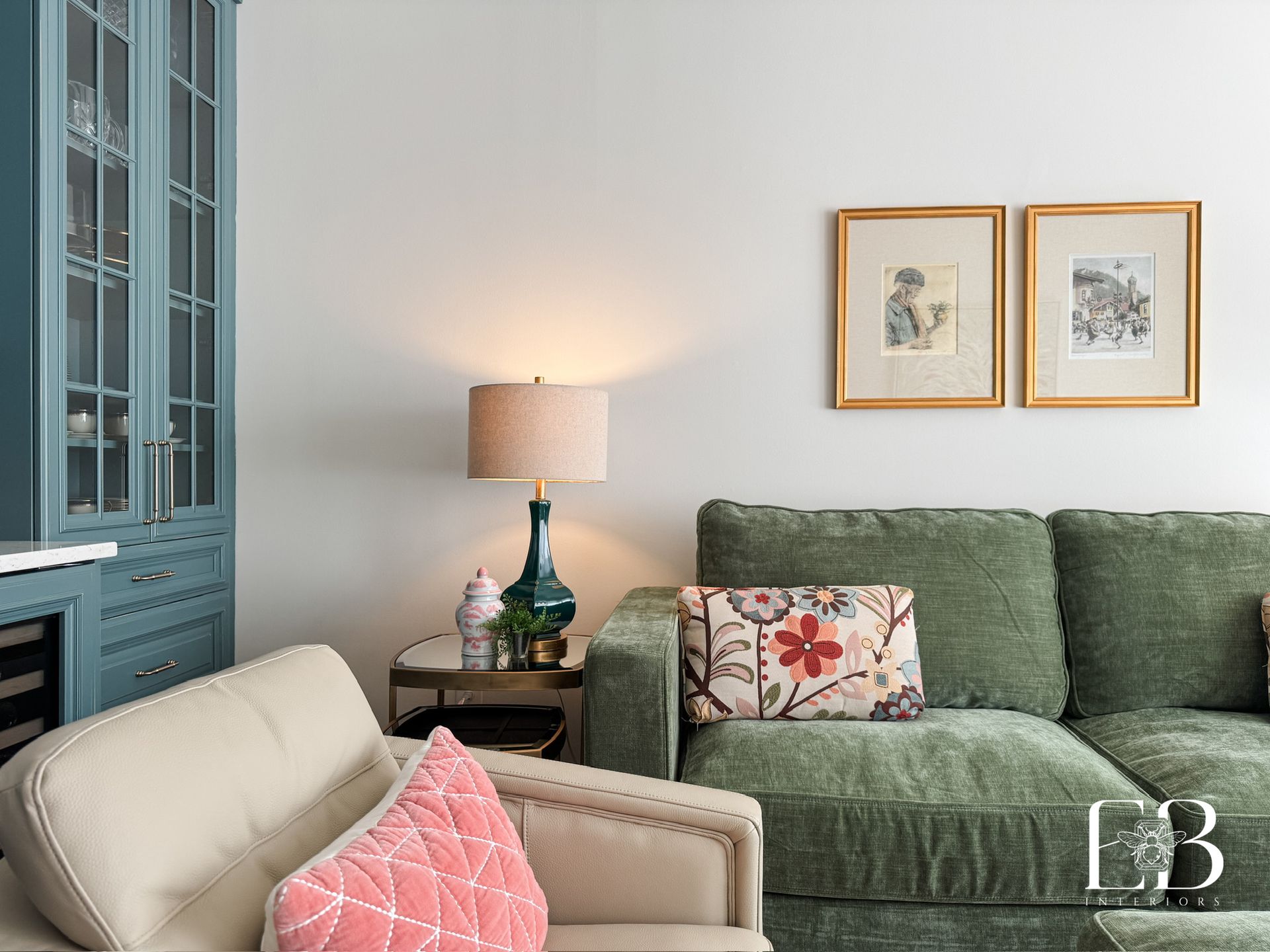 Living room with teal storage cabinet, olive green sofa, and framed art.