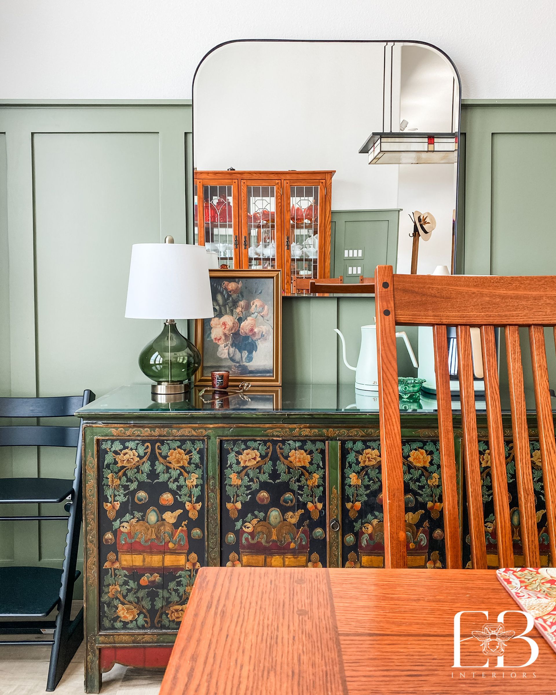 Devotion Row vignette with floral cabinet, green paneling, and Mission-style furniture by Emerald Bee Interiors.