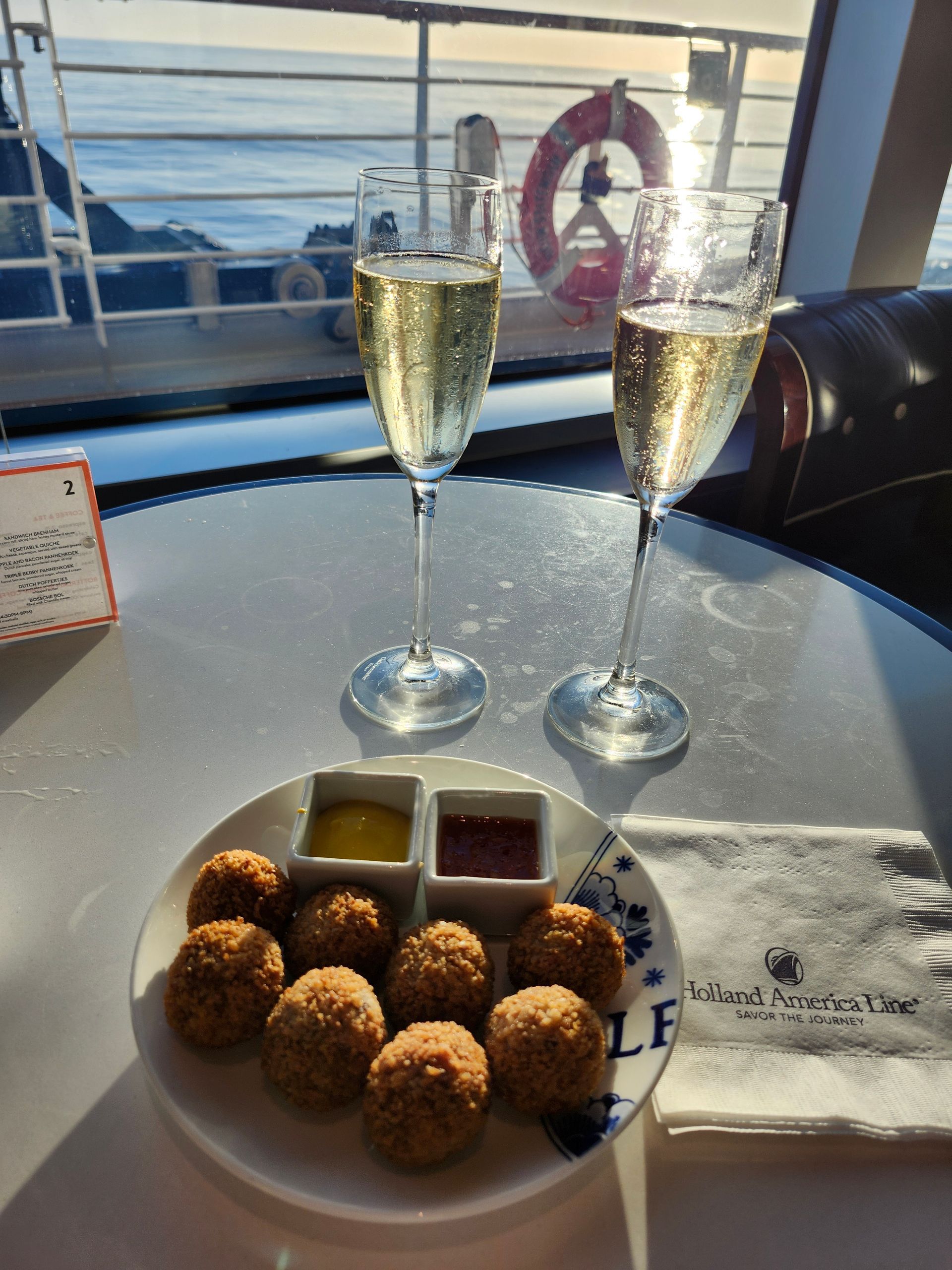 A plate of food and two glasses of champagne on a table