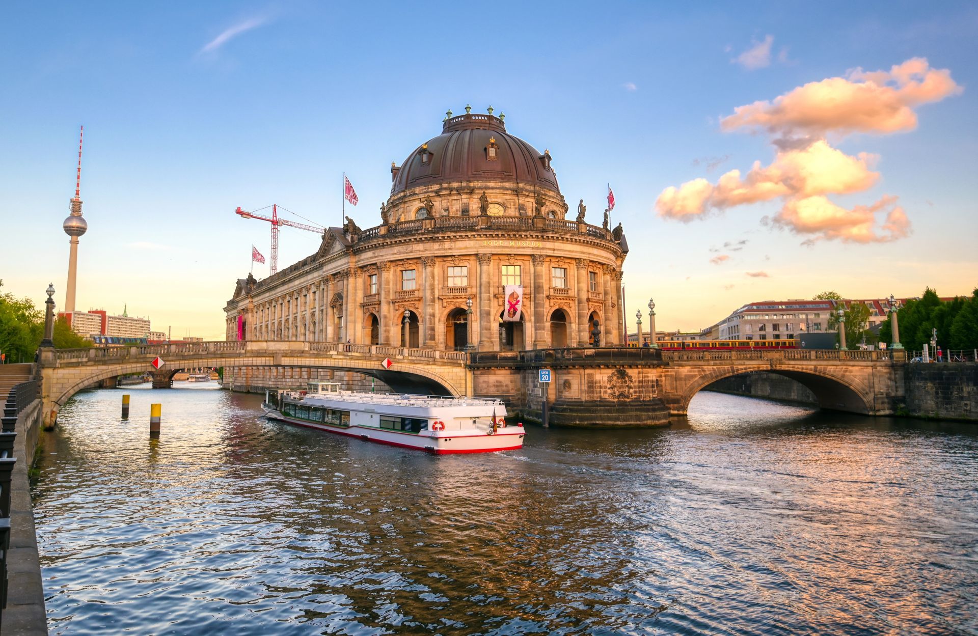 Riverboat on the Spree beside Berlin's historic Bode Museum at sunset
