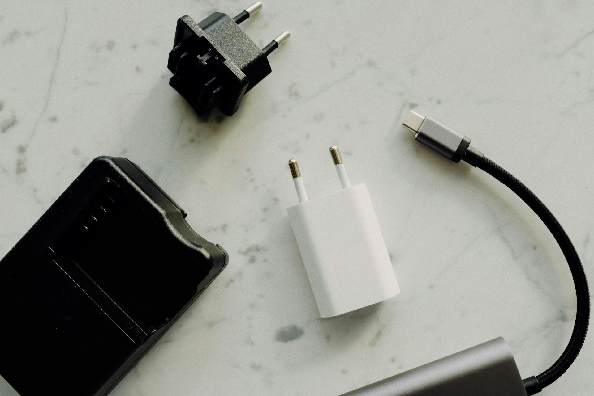 A bunch of chargers are sitting on a table.