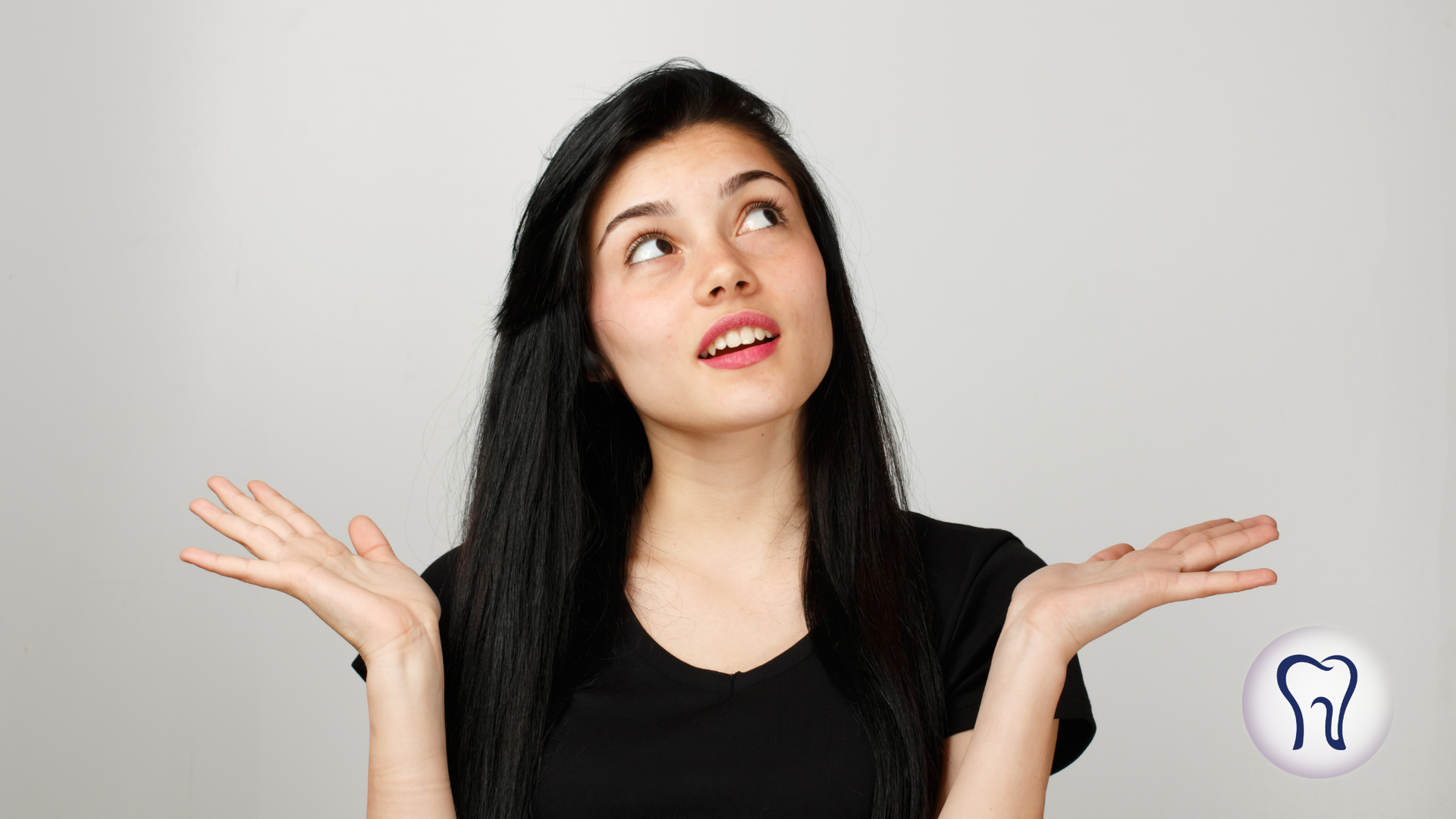 Woman with black hair shrugs, looking upward with a confused expression. Tooth icon in the corner.
